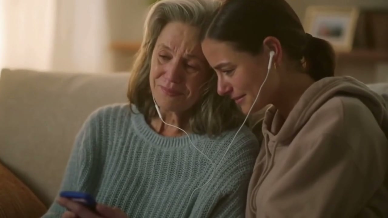 People smiling as they listen to a song on a phone
